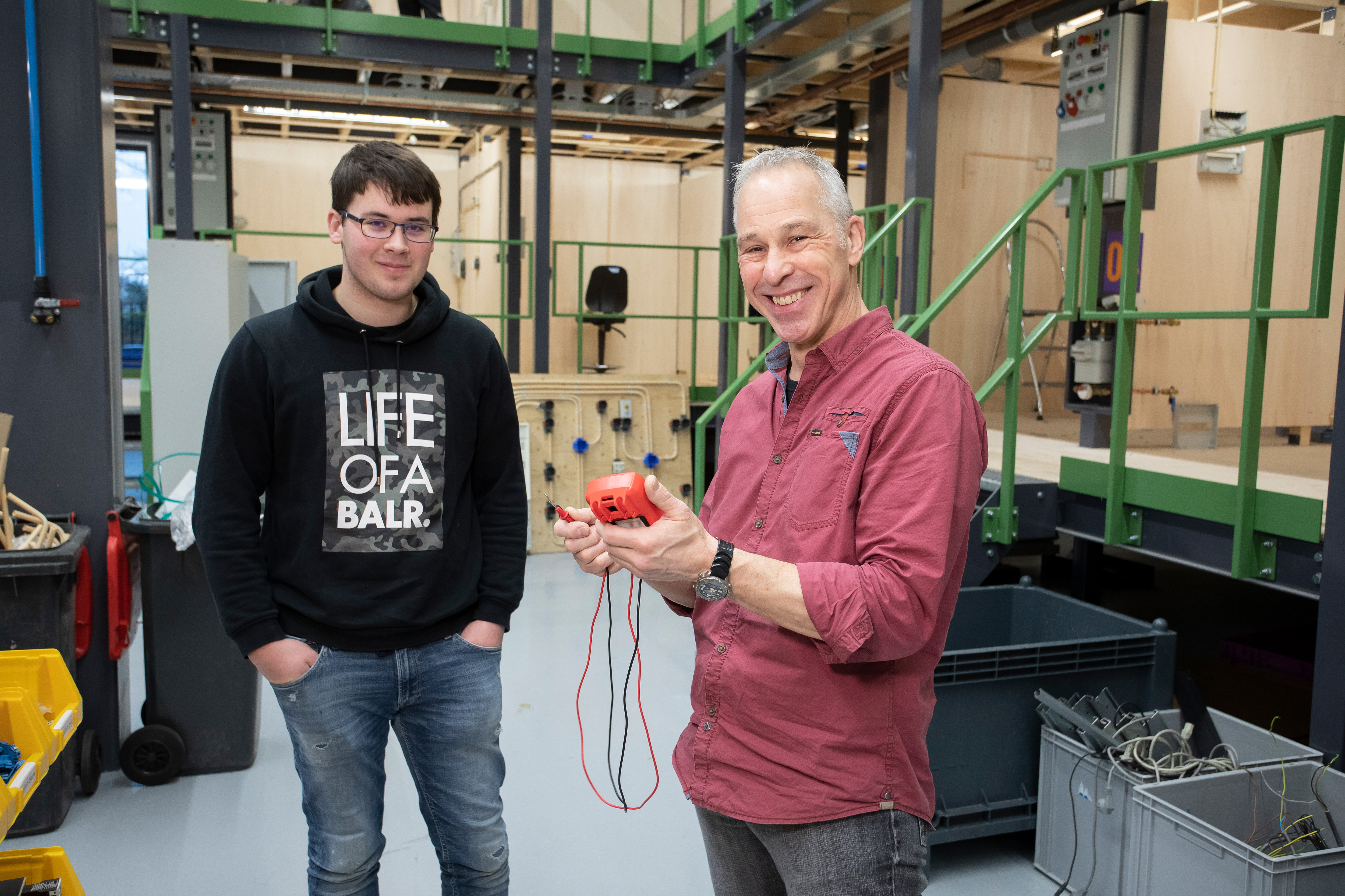 Student en docent lachen naar camera