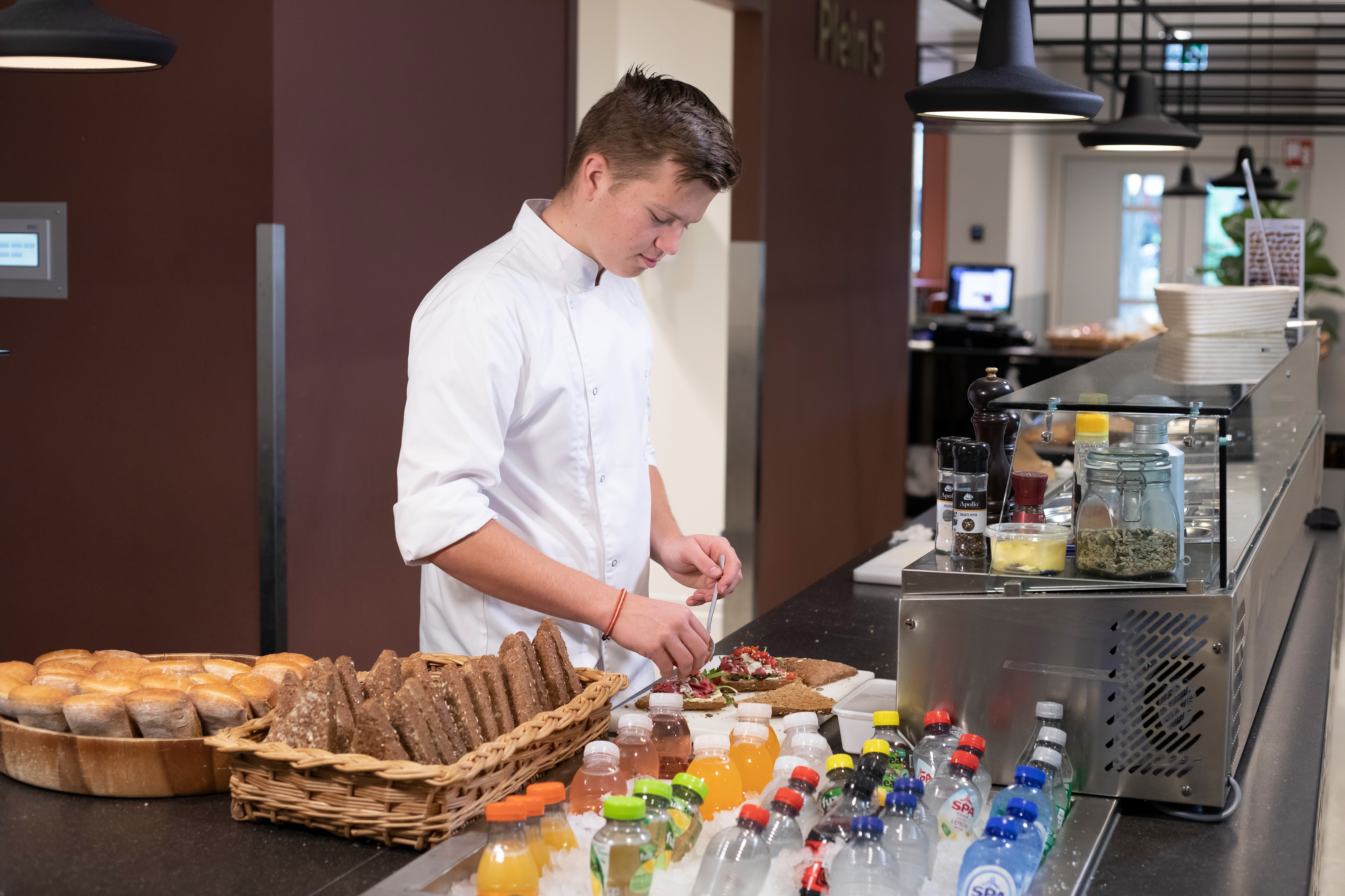 Jongen is bezig met het klaarmaken van luxe broodjes