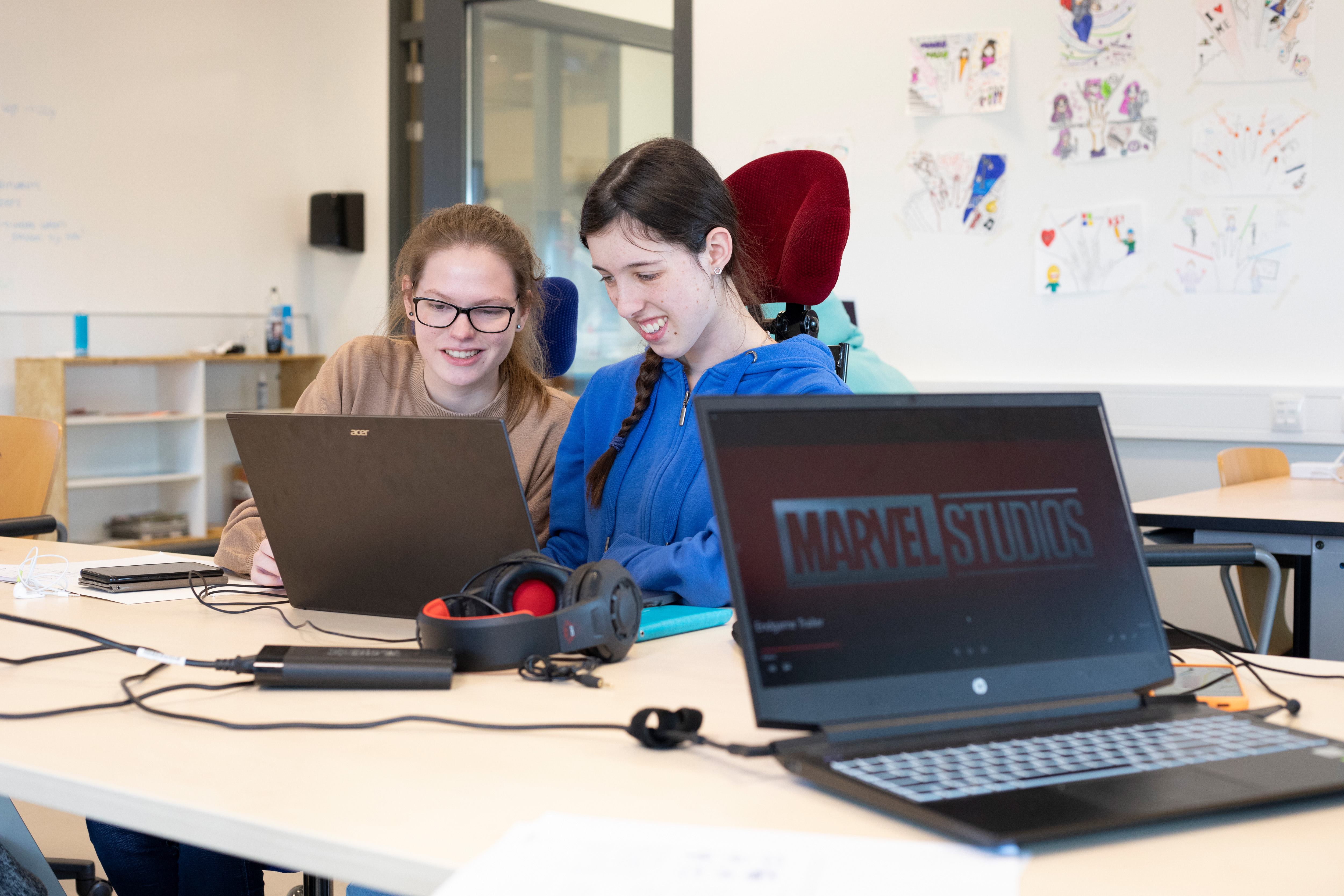 Studenten zitten achter een laptop