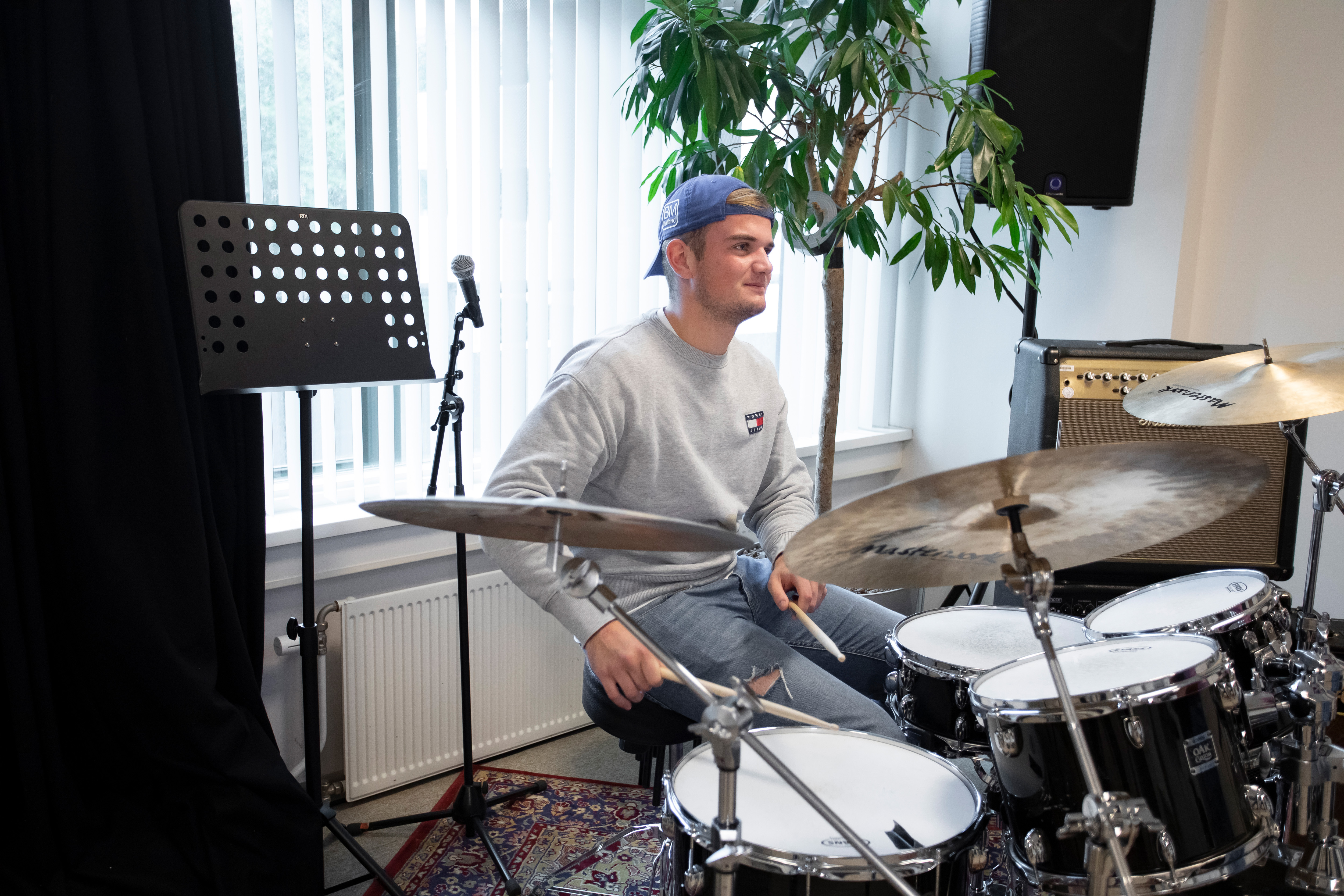 jongen zit achter een drumstel