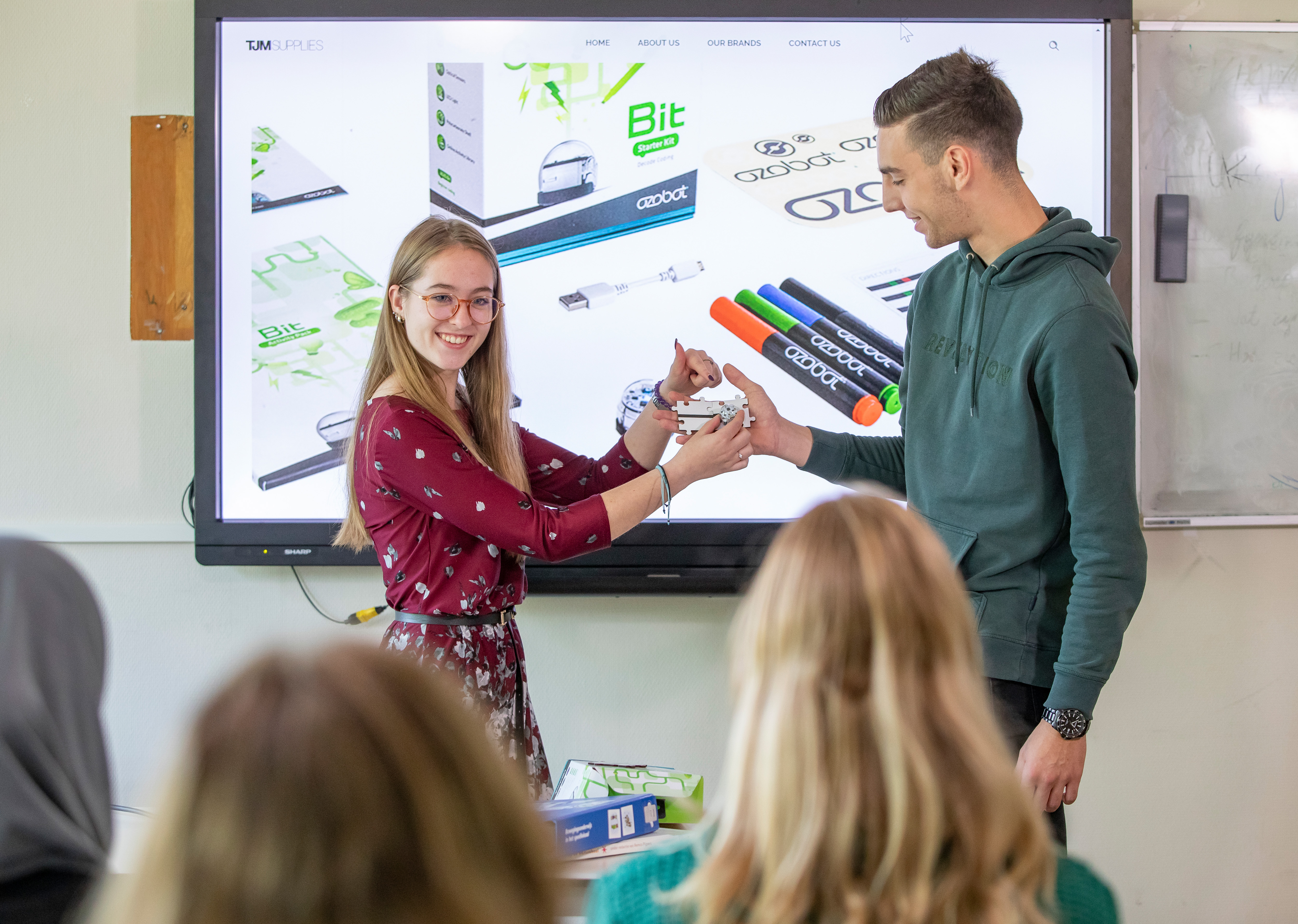 Twee studenten staan voor klas kinderen