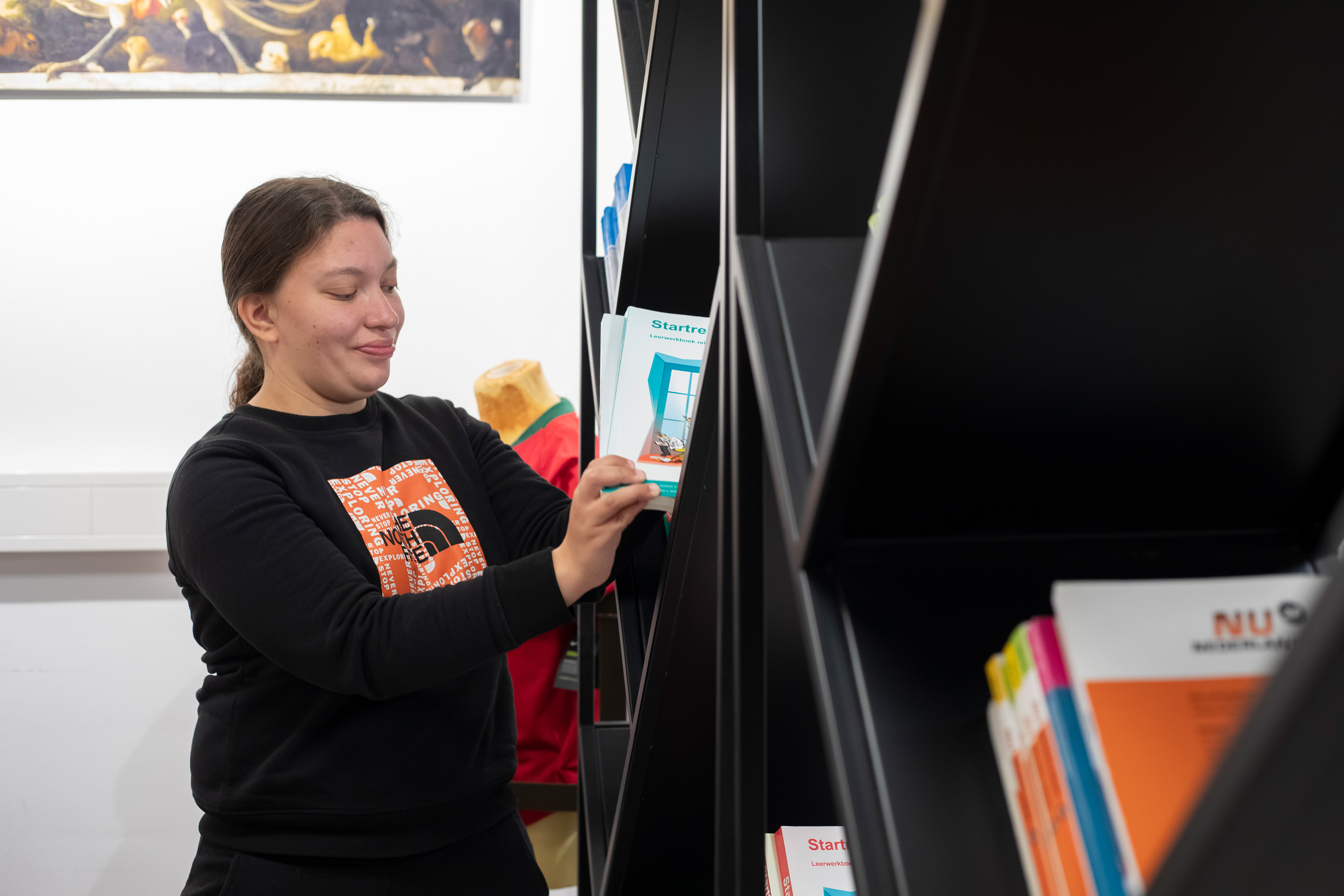 Student zet boeken in kast