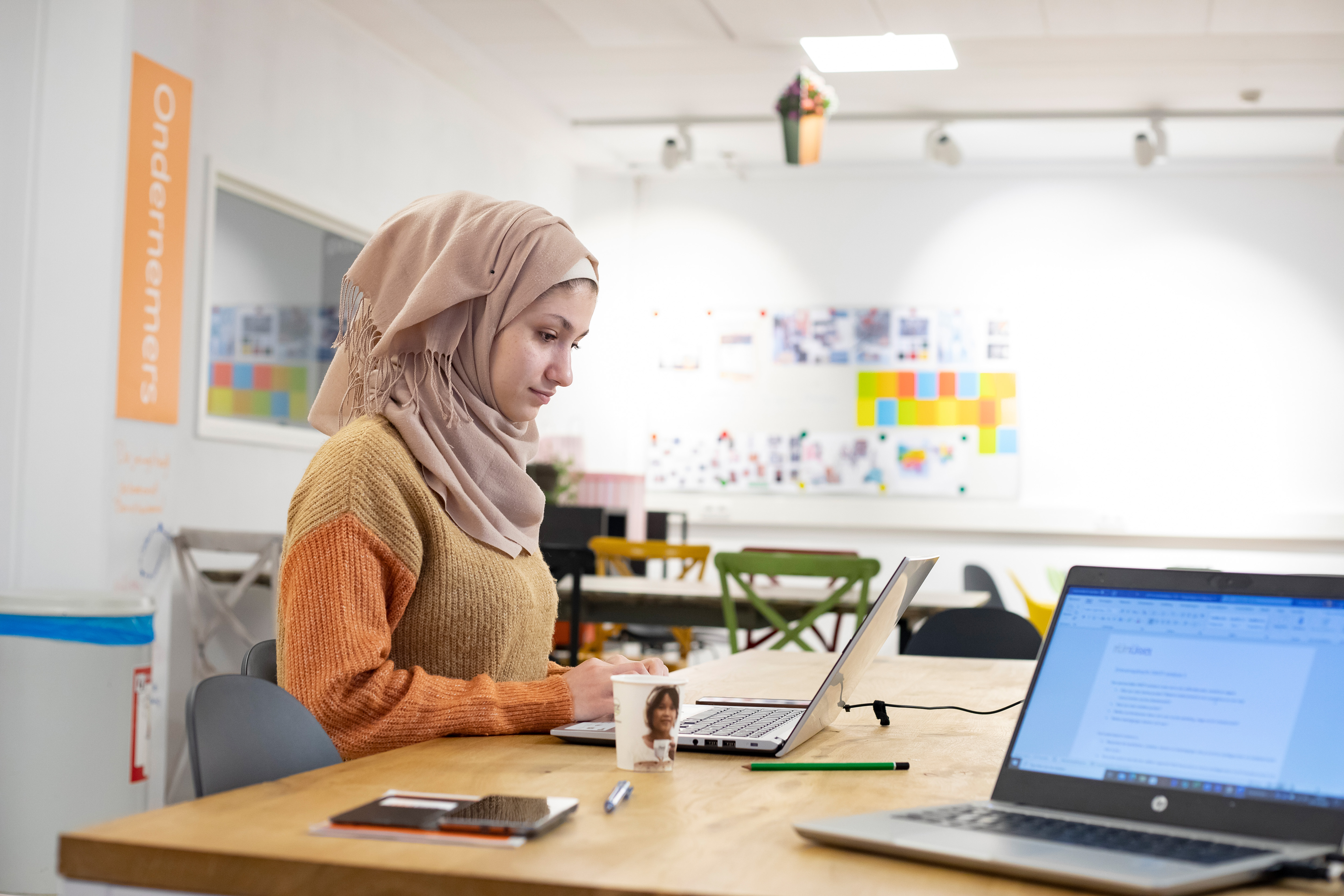 Student zit achter laptop te werken
