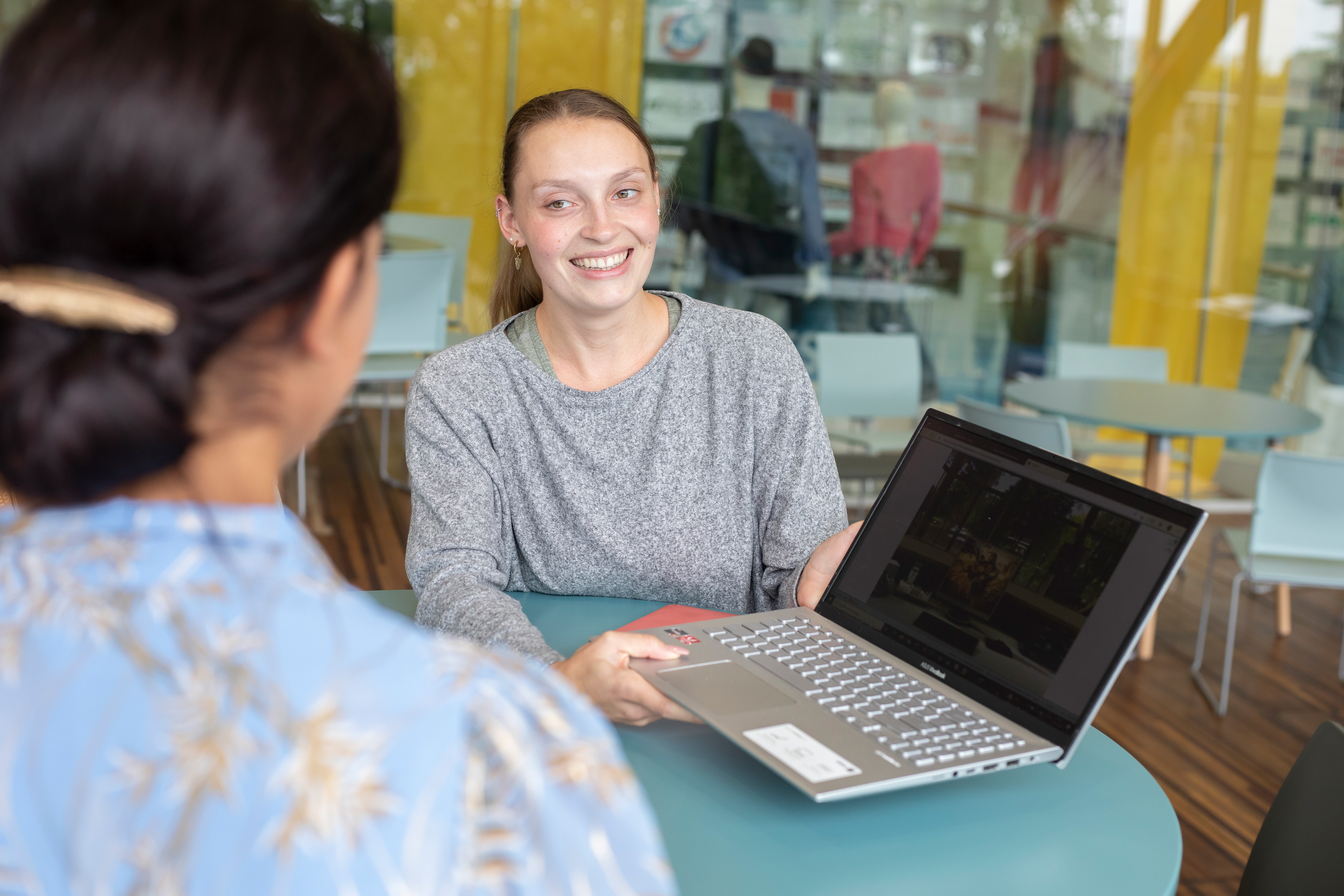 Student laat andere student wat op laptop zien