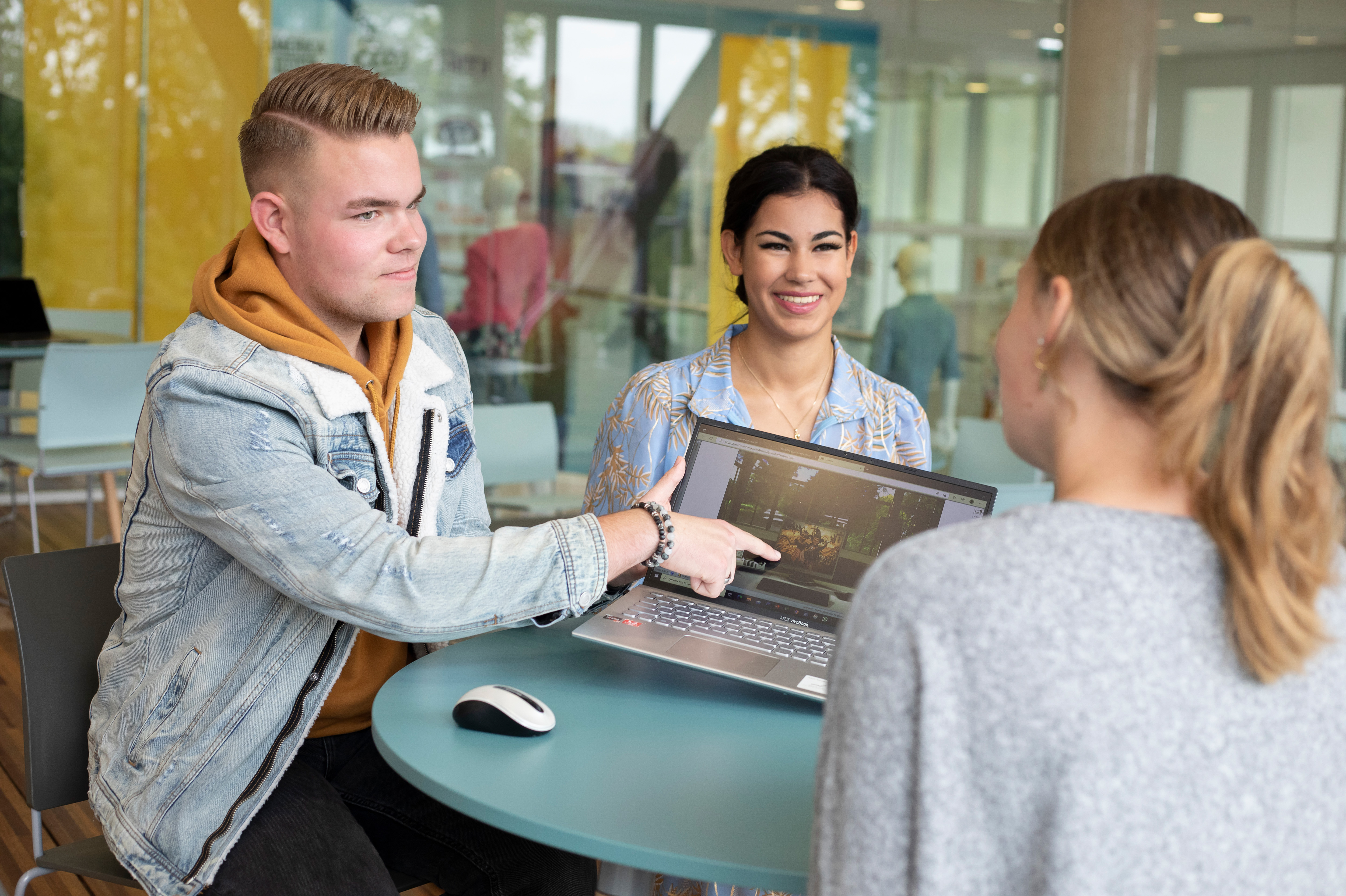 Drie studenten overleggen met elkaar