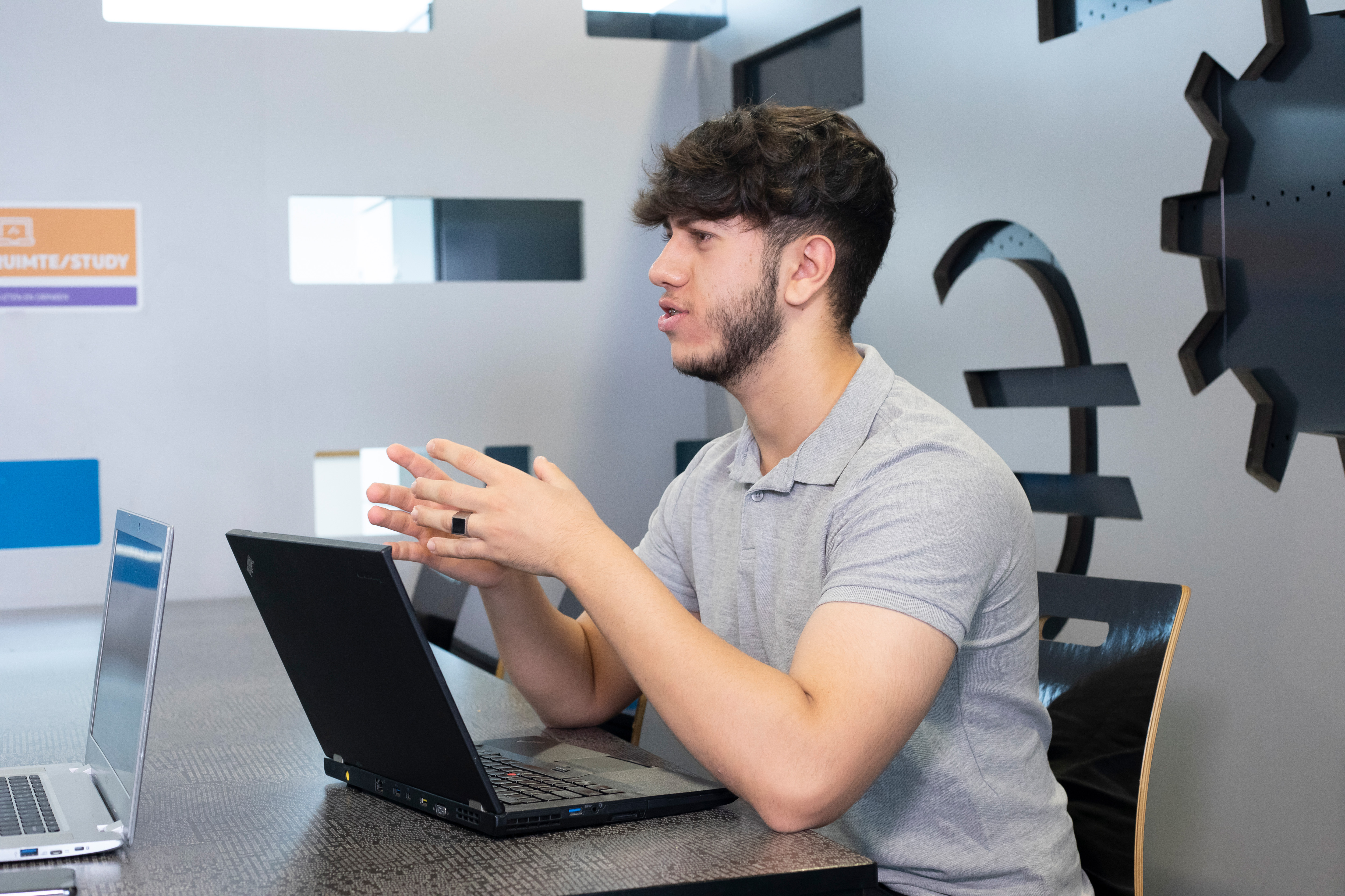 Jongen pratend achter zijn laptop