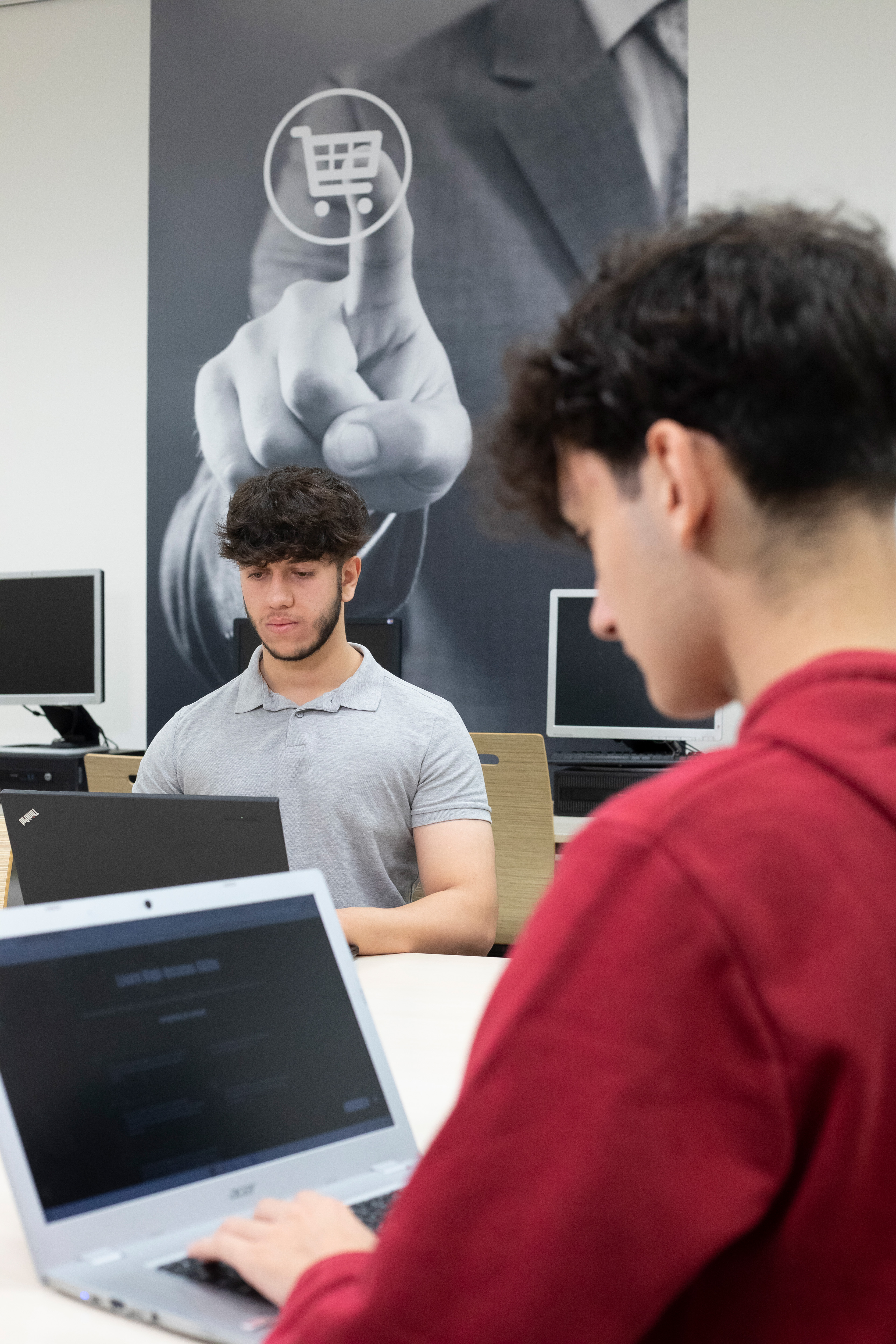 Een jongen werkend achter een laptop