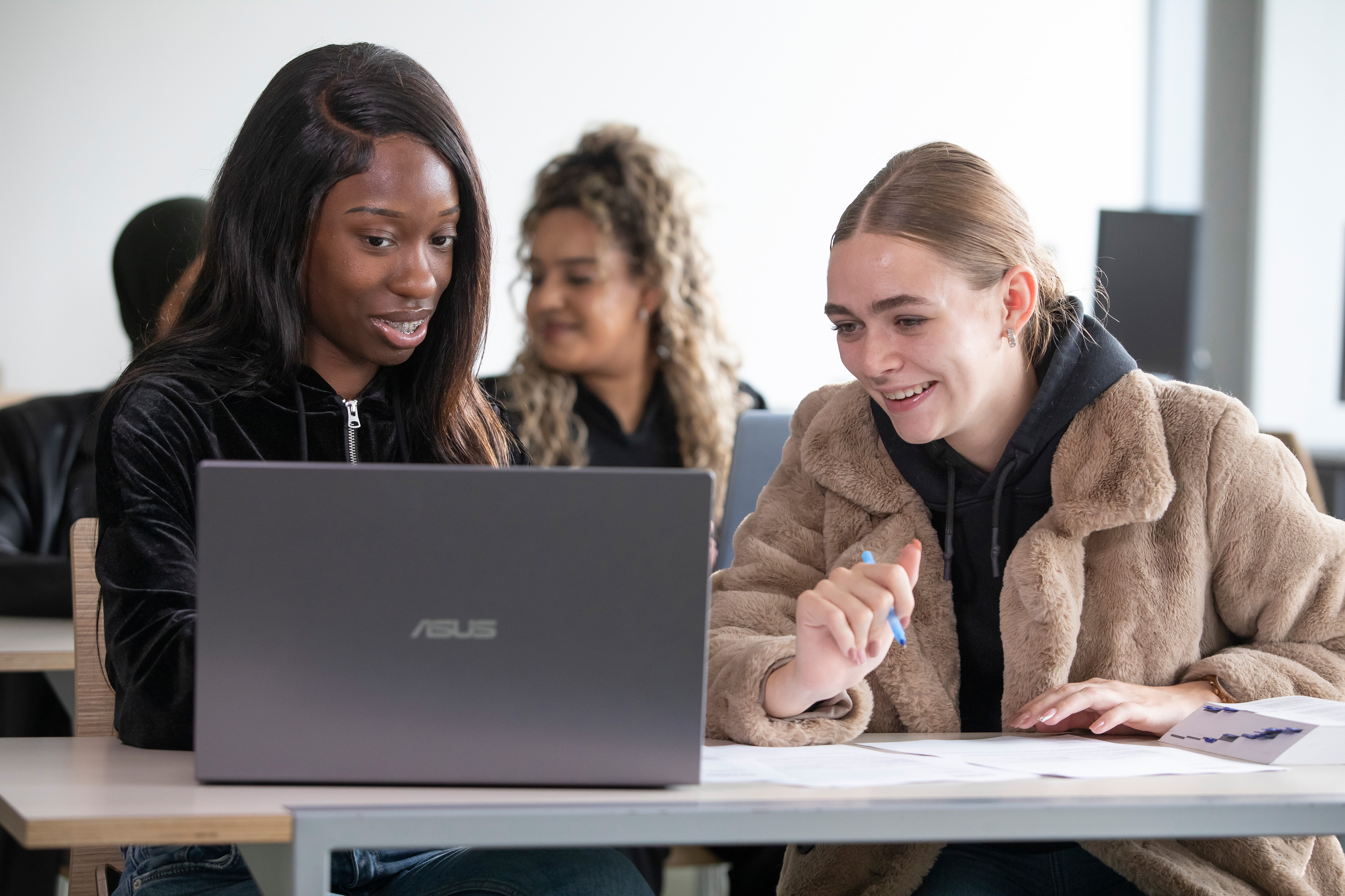Twee studenten overleggen achter laptop