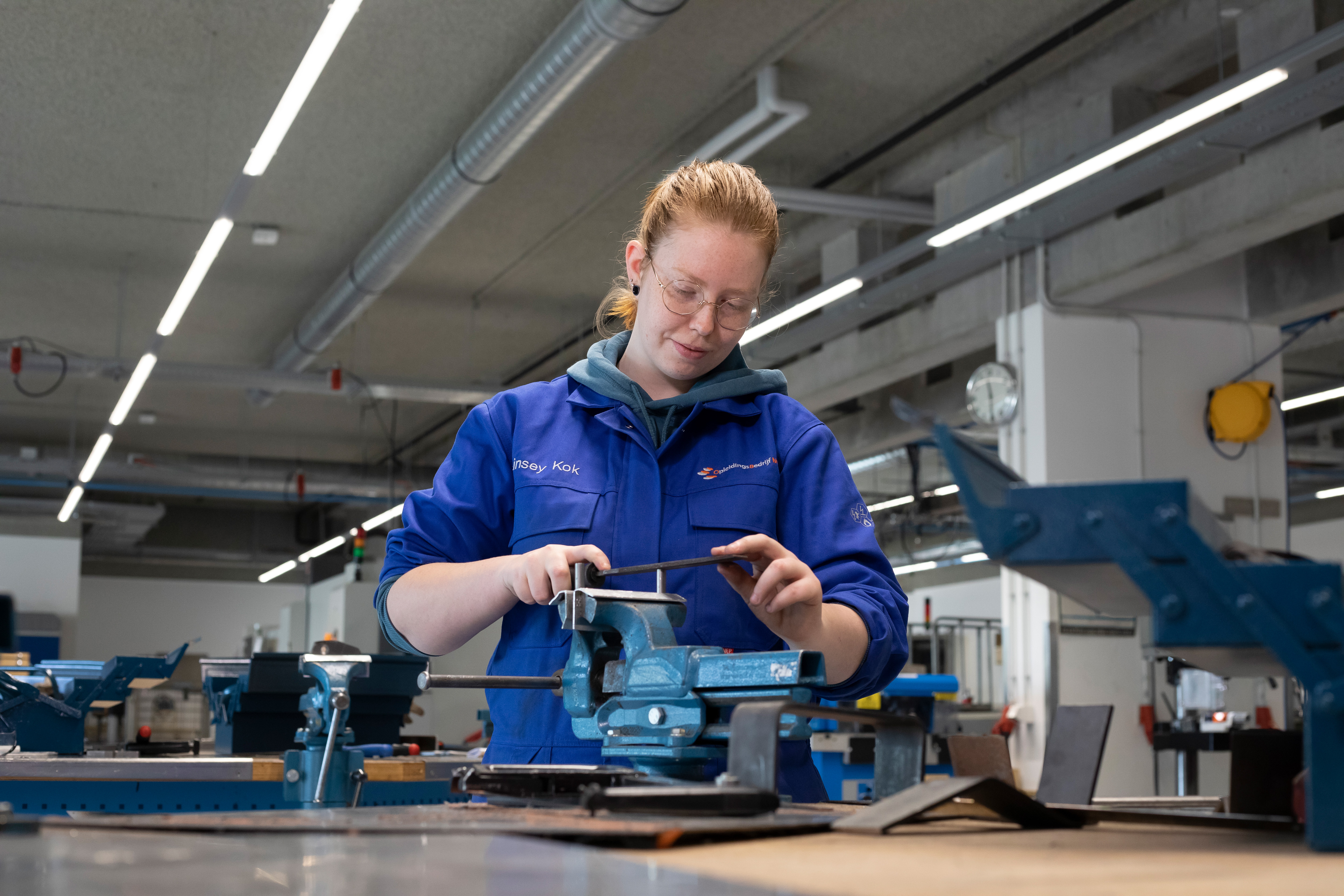 Student bewerkt stuk metaal met machine