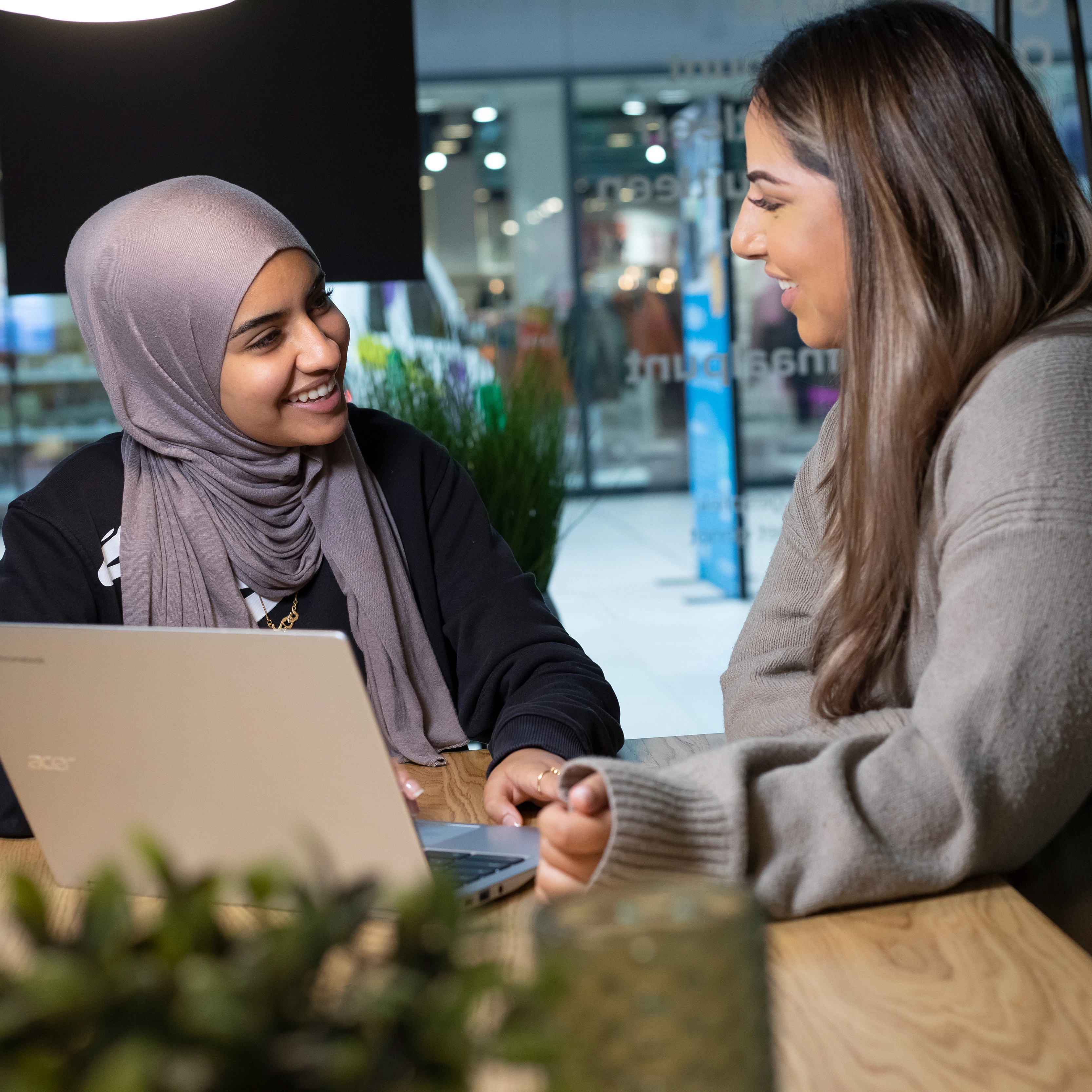Twee studenten zitten achter een laptop