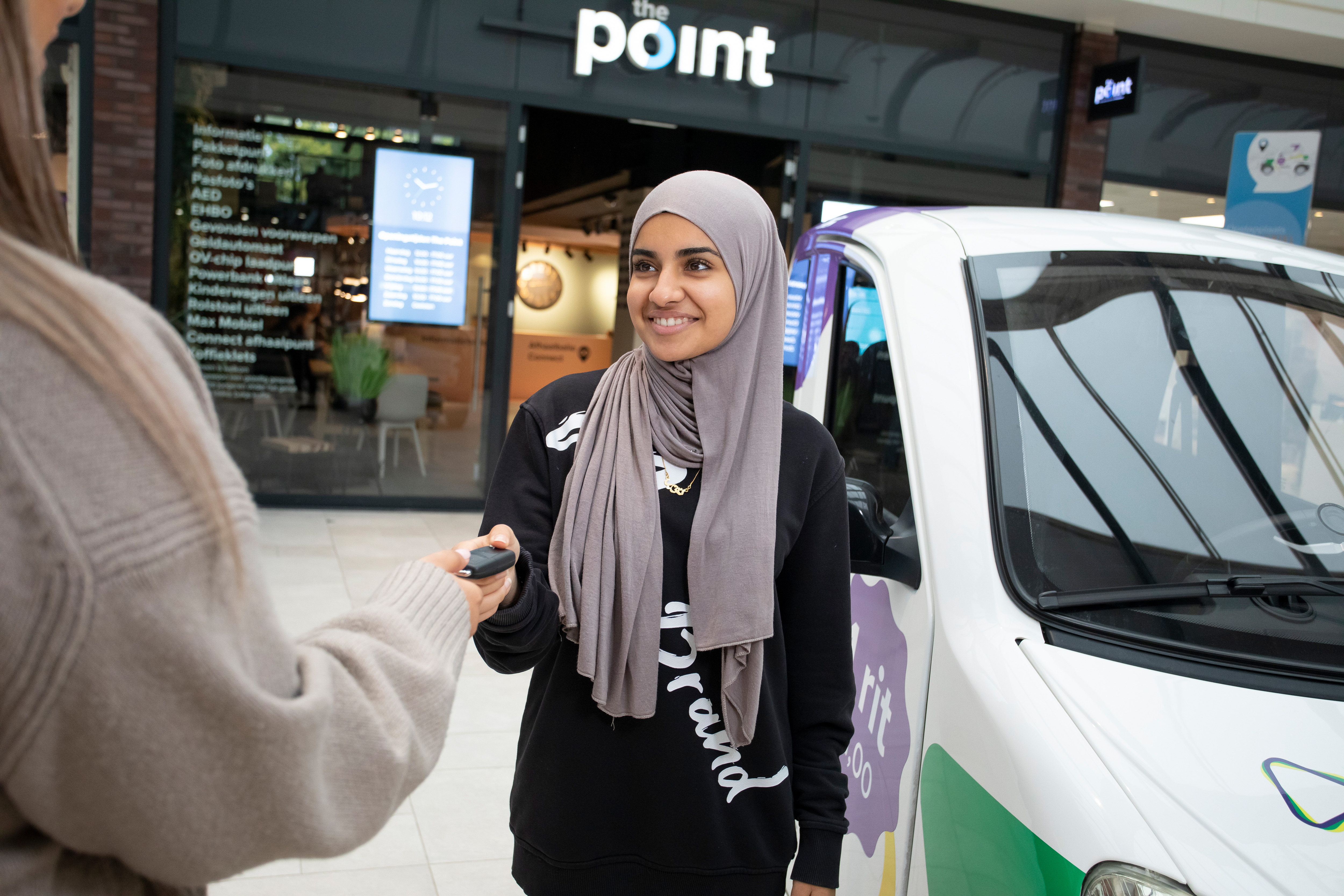 Student geeft een autosleutel aan iemand