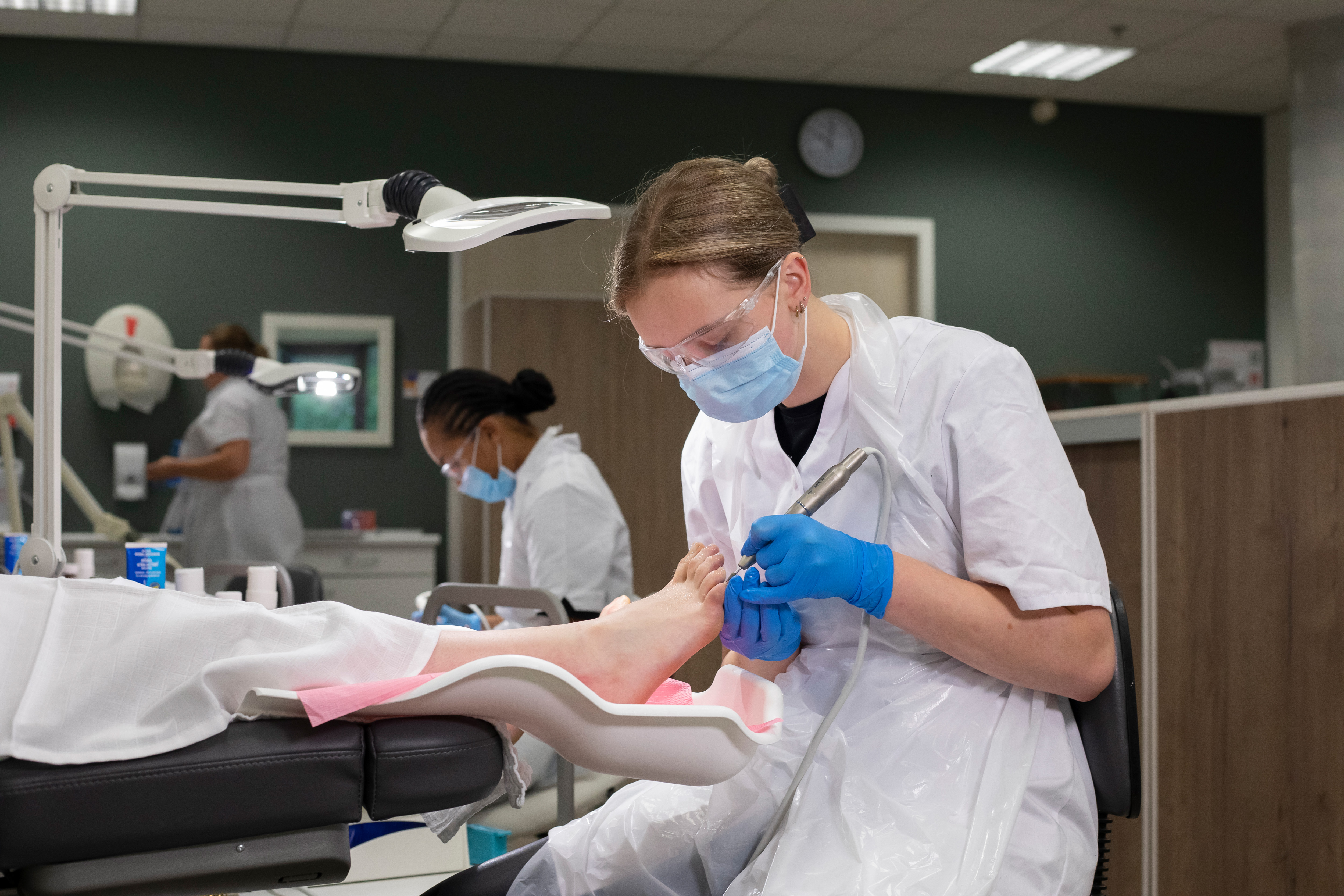 Student is bezig met een vijl en iemands voet