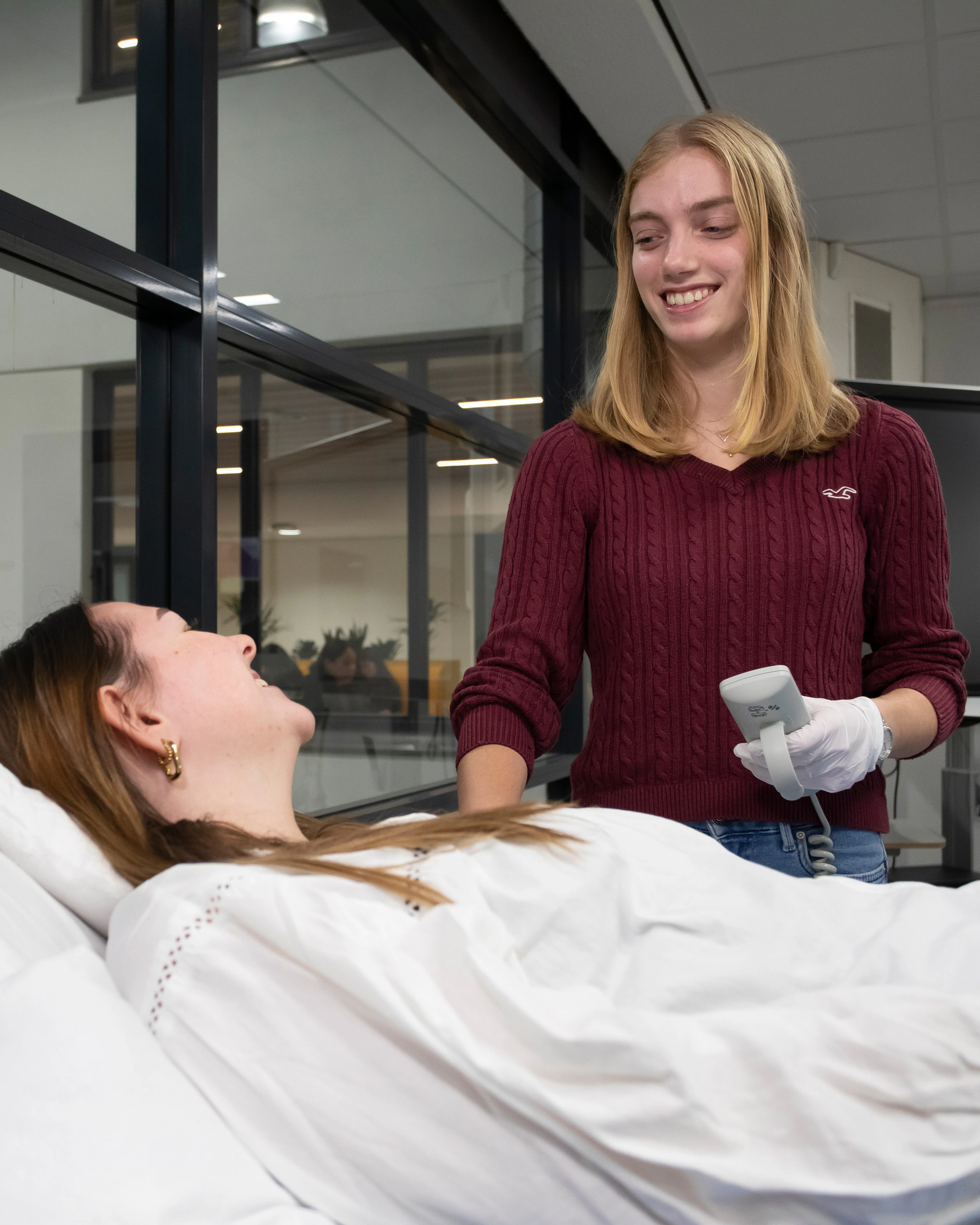 Student staat naast een bed terwijl iemand op bed ligt