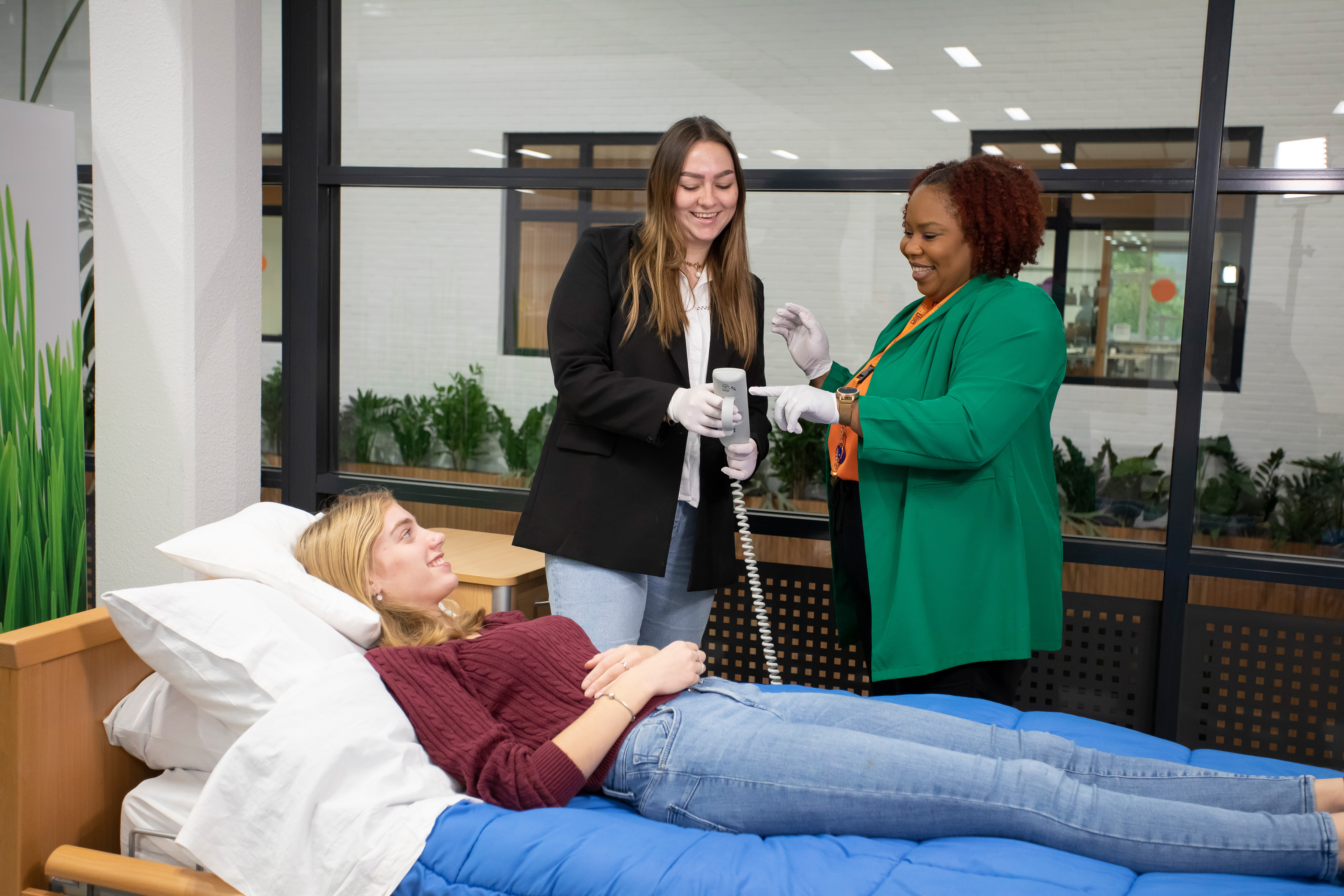 Docent legt student uit hoe ze een afstandsbediening van een bed moet gebruiken