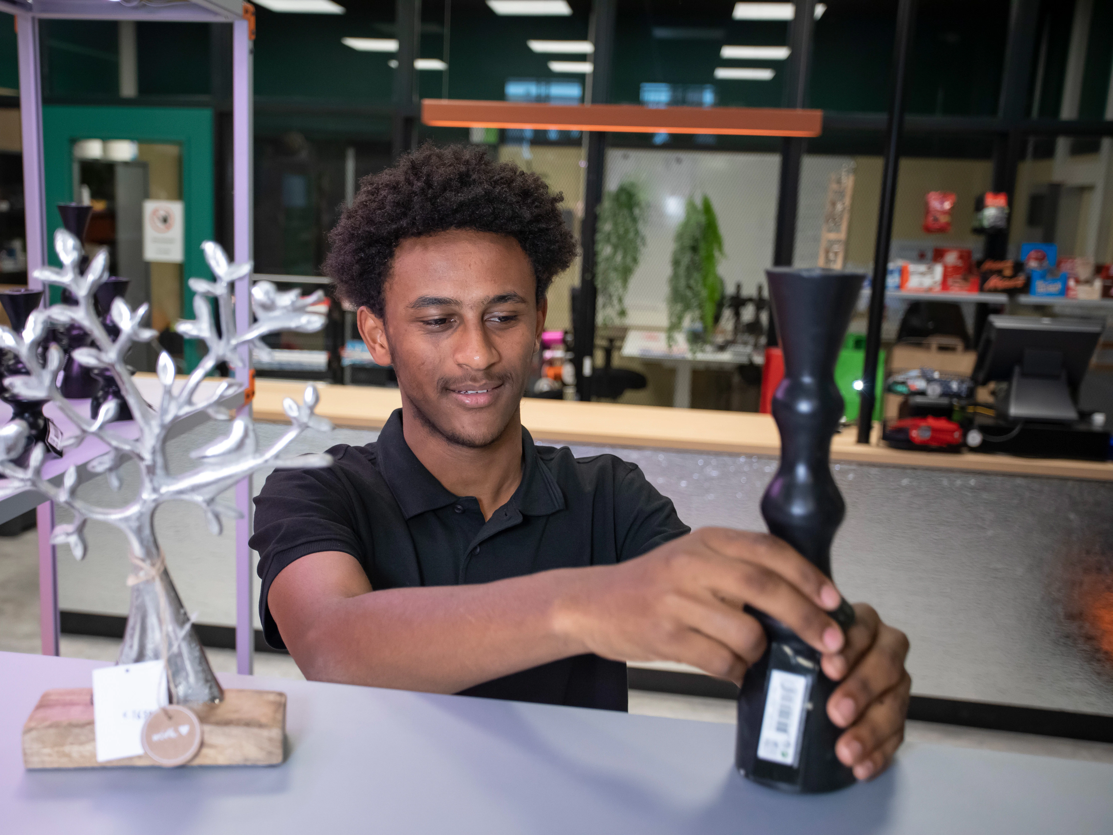 Student zet een kaars op een schap in de winkel