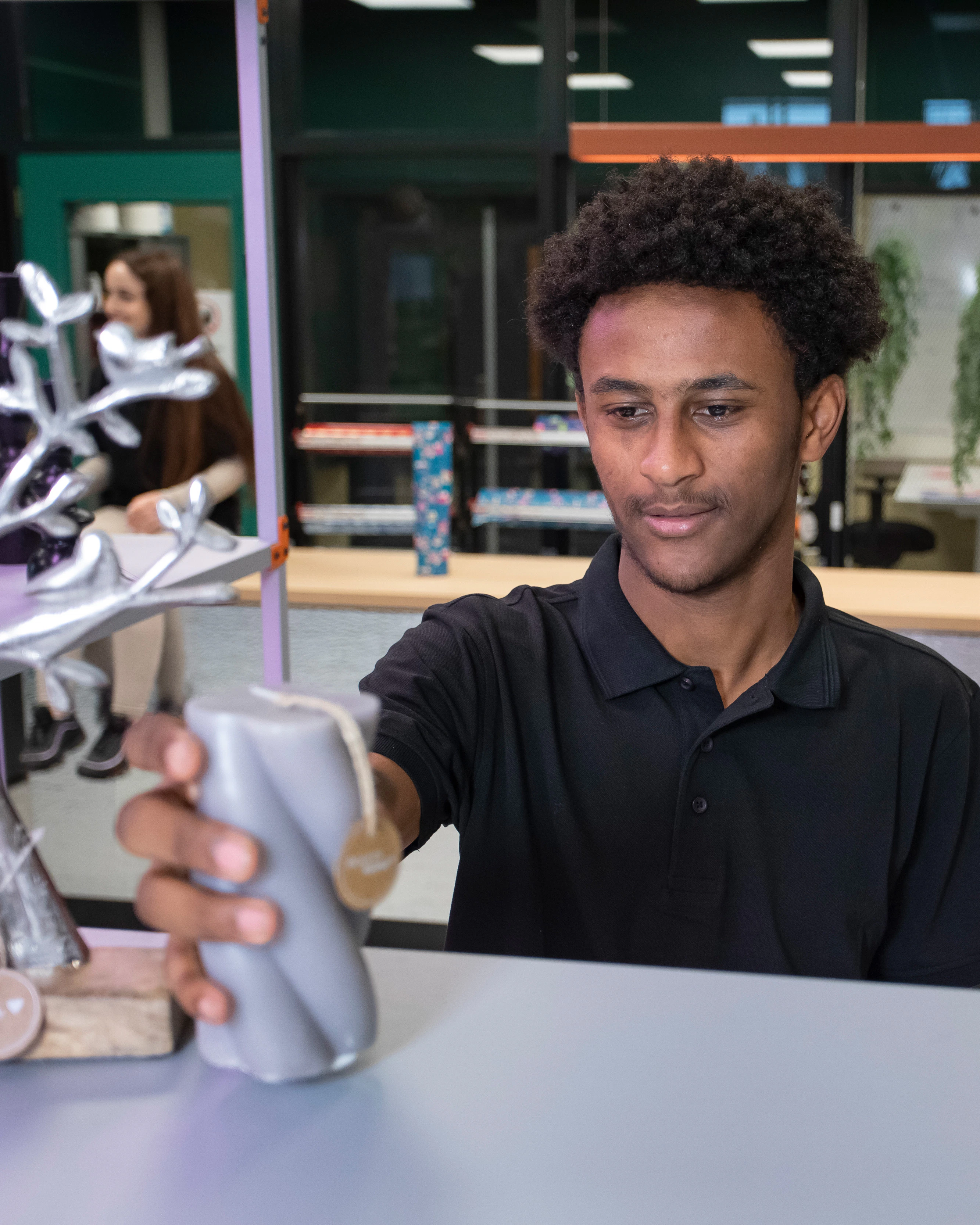 Student zet een kaars op een schap in de winkel