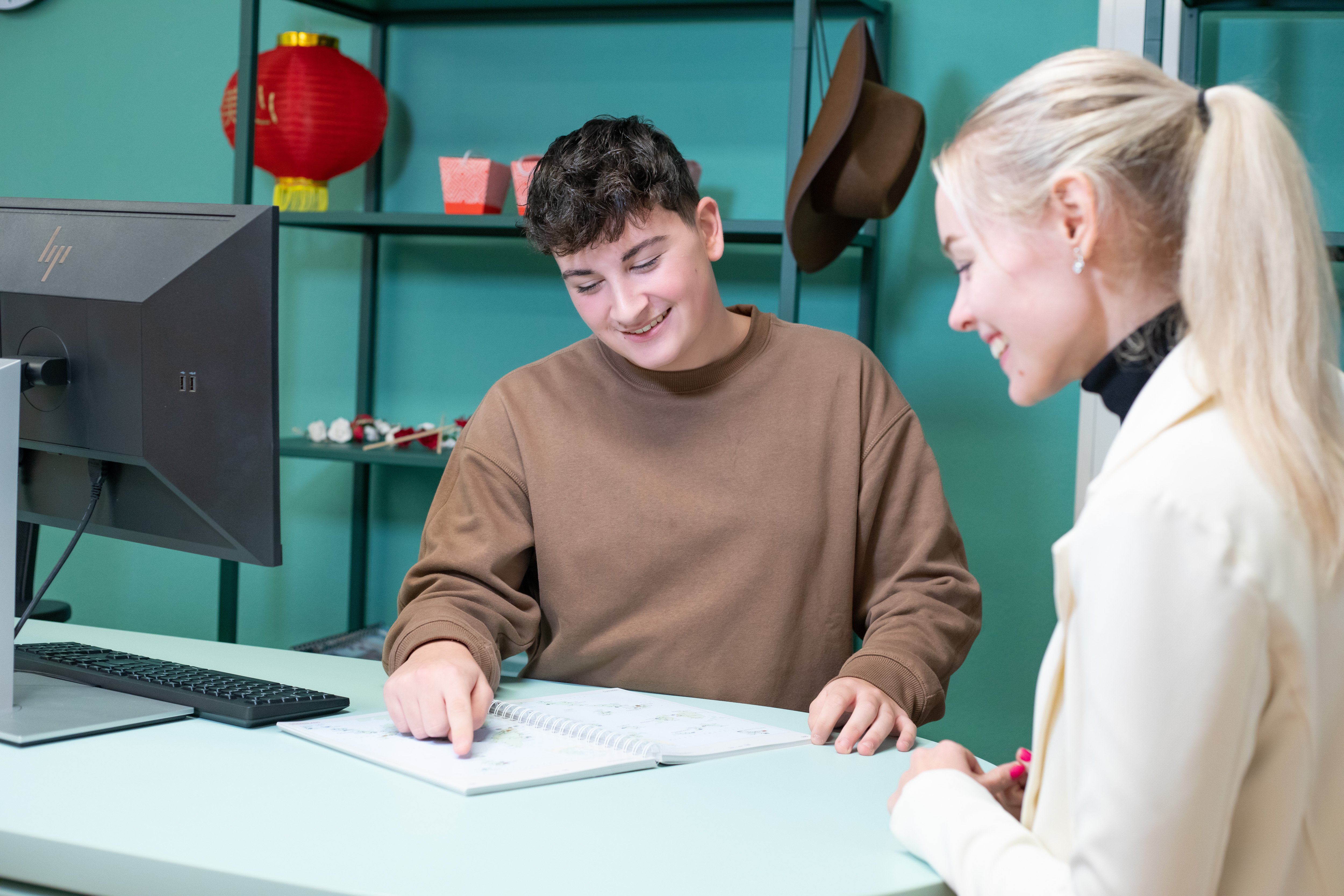 Student wijst op een papier terwijl een andere student toekijkt